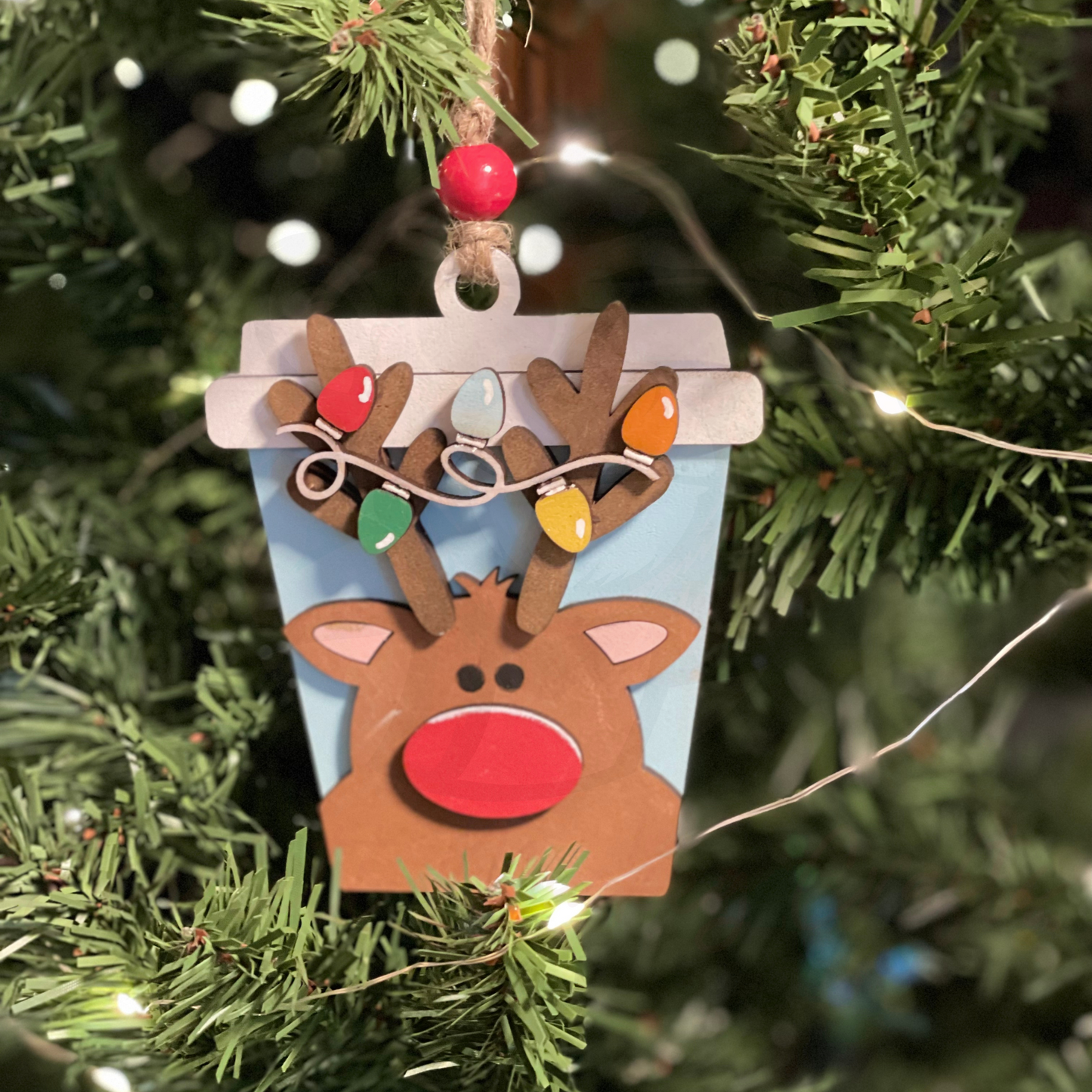 Christmas ornament featuring a latte-themed reindeer with a money or gift card holder pocket, hand-sculpted and painted from wood.