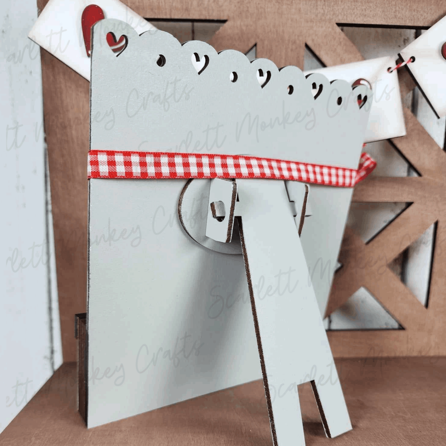 Paintable wood Valentine's Day tiered tray set with heart cutouts and red ribbon.