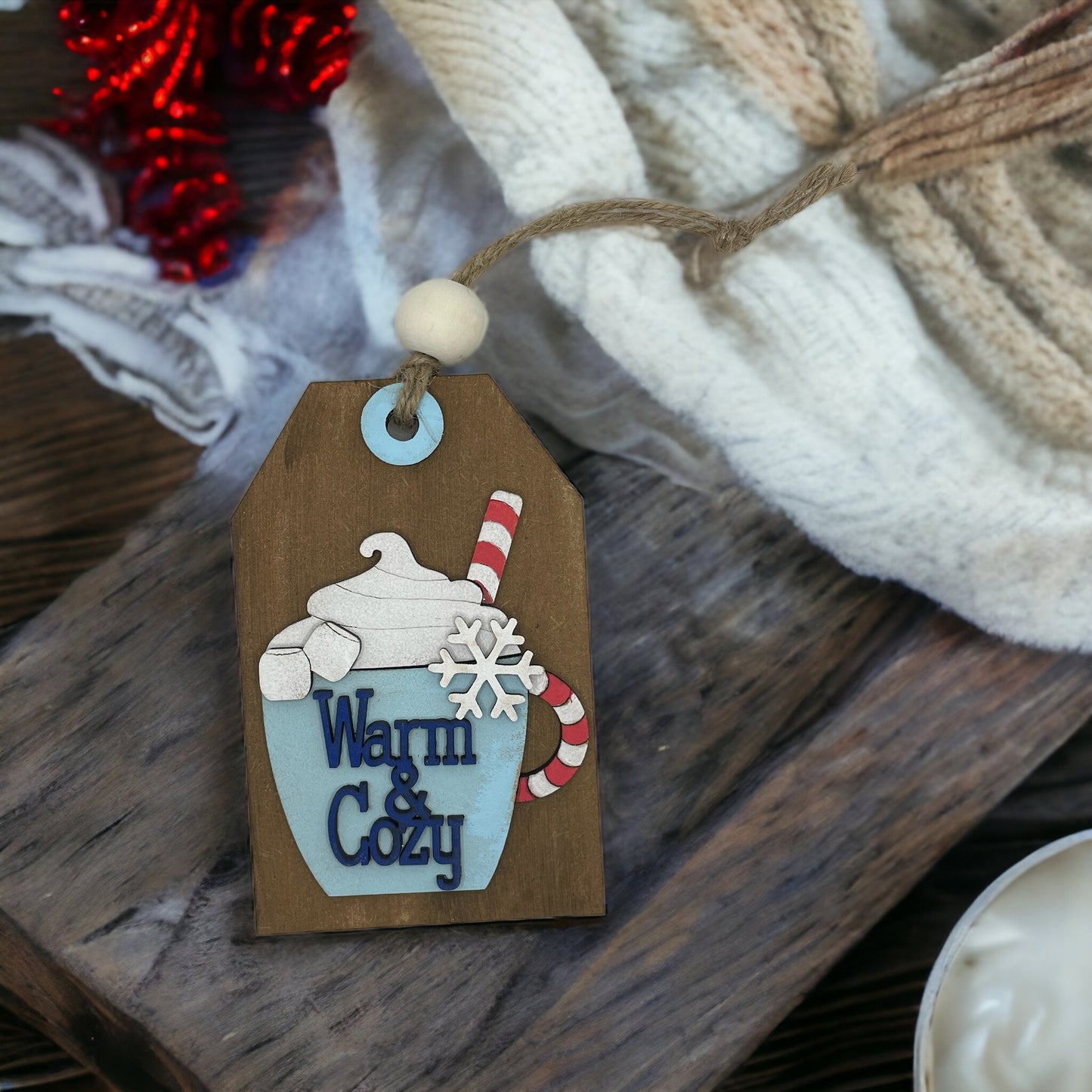 Christmas ornament with pocket for money or gift card, hand-sculpted wood with "Warm & Cozy" design.