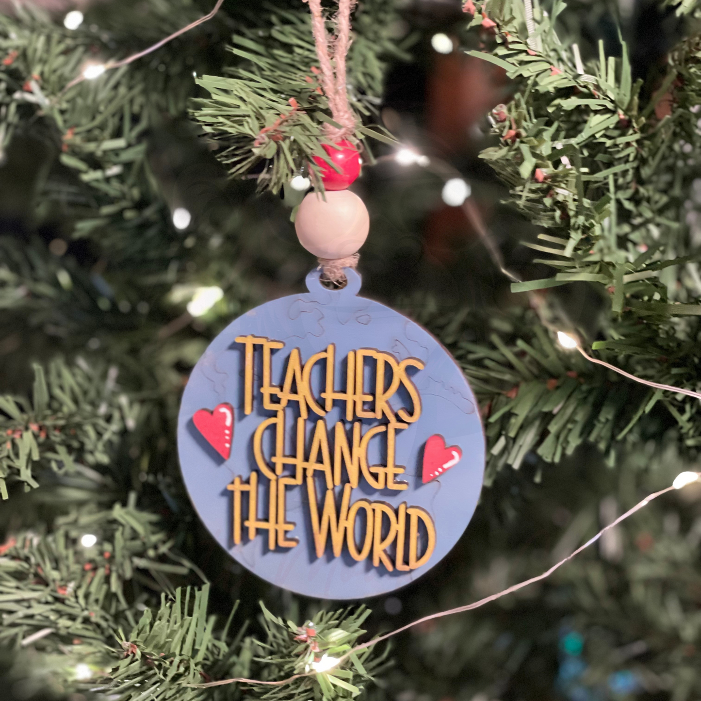 Handcrafted round Christmas ornament for teachers hanging on a tree.