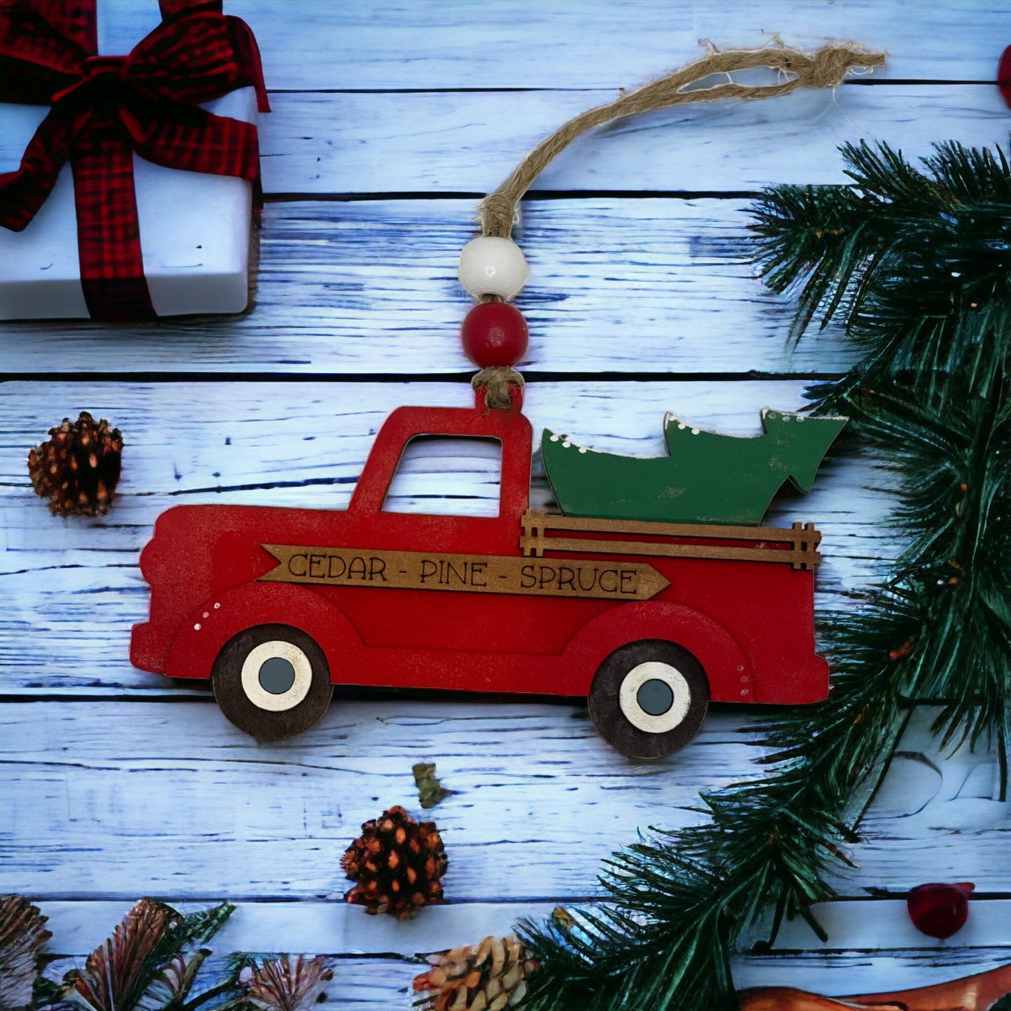 Christmas ornament featuring a hand-painted red farm truck with a rustic design.