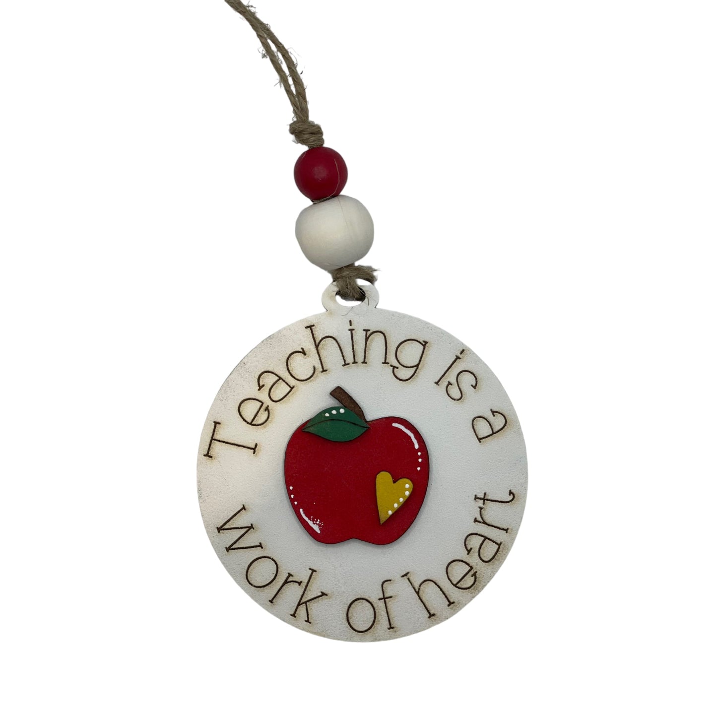 Handcrafted Christmas ornament with apple design, featuring "Teaching Is a Work of Heart" inscription.