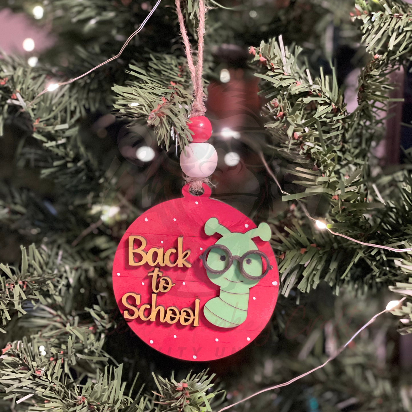 Hand-painted Back to School Christmas ornament featuring a cute bookworm on a red wooden circle with natural twine hanger