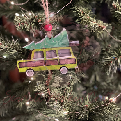 Hand-painted family Christmas truck ornament hanging on tree with festive design and green Christmas tree on top