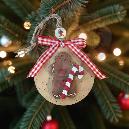 Hand-painted gingerbread and candy cane wooden Christmas ornament with red plaid bow hanging on tree
