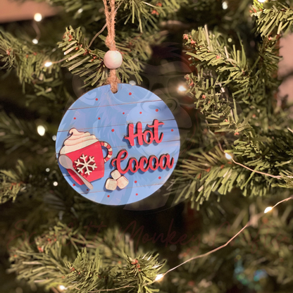 Hand-painted hot cocoa Christmas ornament on tree with red mug and marshmallows, cozy holiday decoration