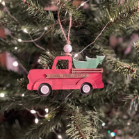 Hand-painted red farm truck Christmas ornament hanging on tree with rustic farmhouse style