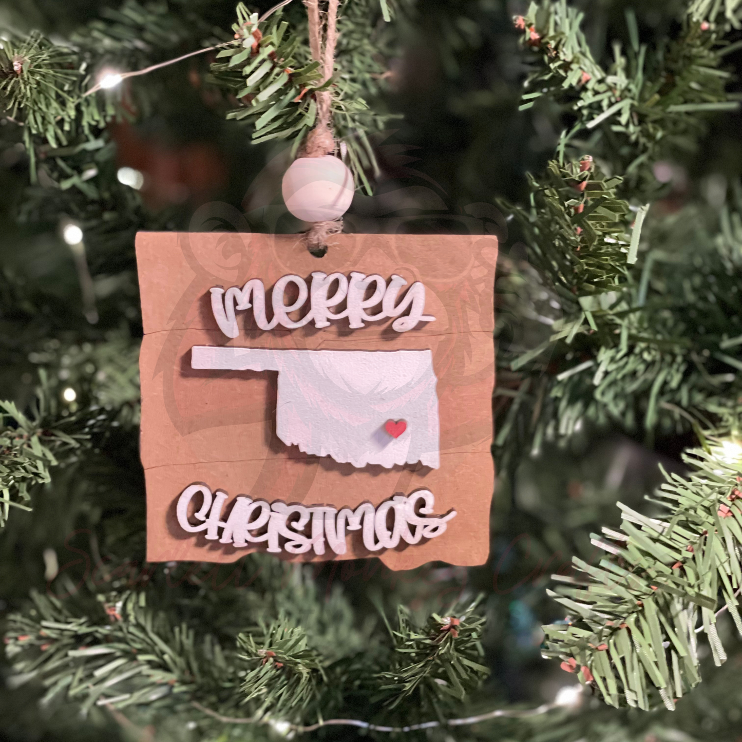Hand-painted Merry Christmas Oklahoma wooden ornament hanging on Christmas tree