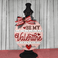 Valentine Door Hanger with vibrant colors and intricate design on black stand.