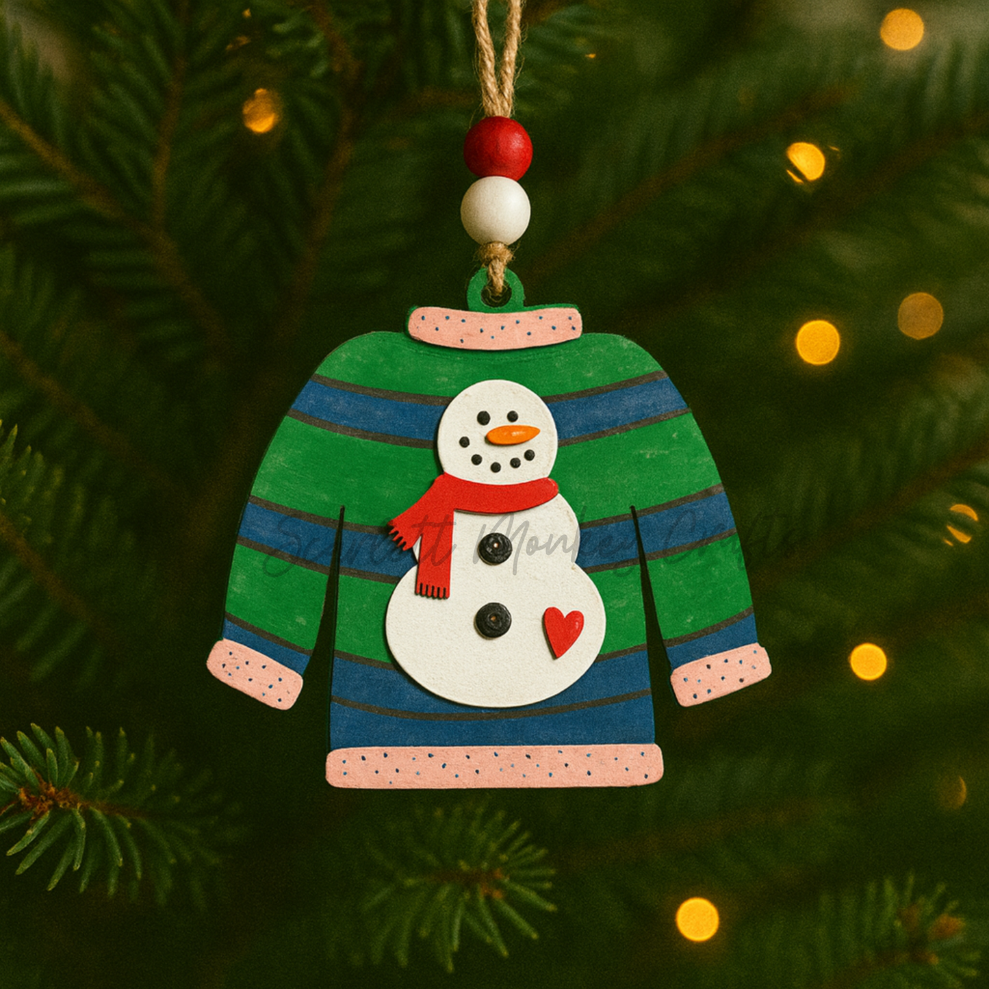 Hand-painted wooden Christmas ornament shaped like an ugly sweater with a snowman in a red scarf and heart detail